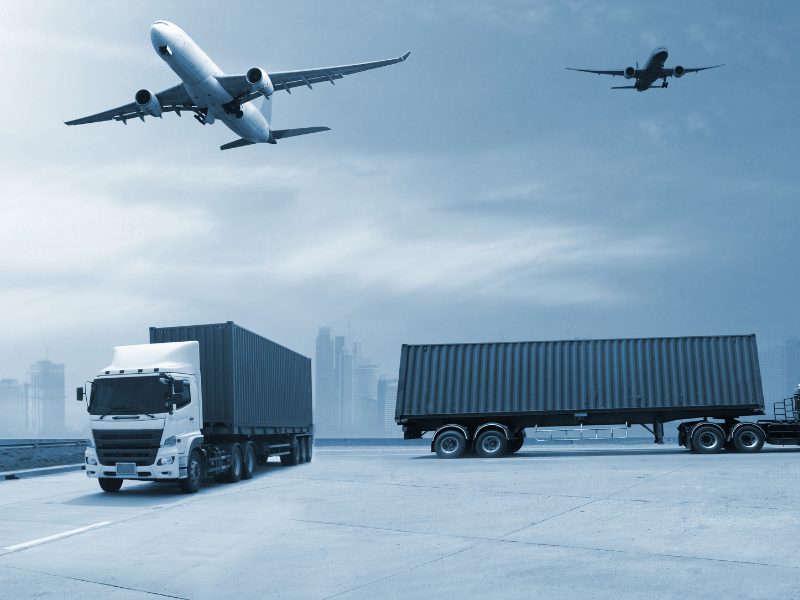 Two cargo planes in the sky and two trucks on the ground representing global exports and imports moving through air and land logistics networks.